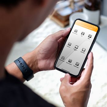 Smartphone von zwei Händen gehalten, auf dem Bildschirm die ZAKB-App