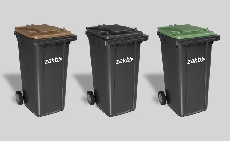Werden ab 2026 eingeführt: Schwarze Mülltonnen mit farbigen Deckeln Drei schwarze Mülltonnen mit verschiedenfarbigen Deckeln stehen nebeneinander