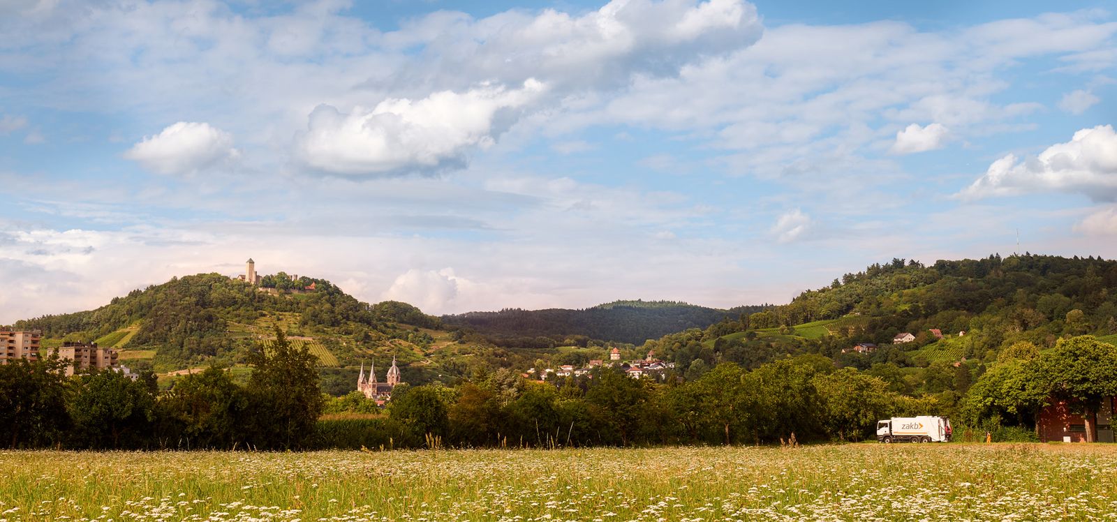 Panorama-Ausschnitt Bergstraße, ZAKB-Müllauto und Heppenheimer Dom vor Bergen mit der Starkenburg