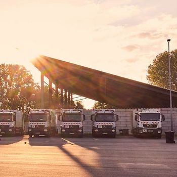 Parkende Müllautos im Sonnenaufgang