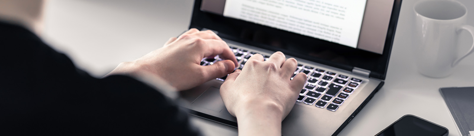Hände tippen auf Laptop-Tastatur